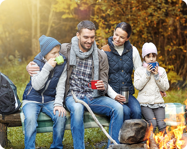 Family enjoying drinks by campfire